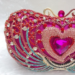 Detailed macro view of multi-colored crystals and heart-shaped gemstone on evening bag