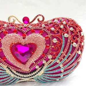 Close-up of luxury heart crystal evening clutch with pink gemstone and vibrant rhinestones