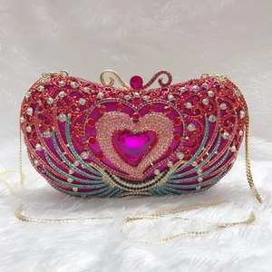 Detail of heart-shaped luxury evening clutch with colorful rhinestones and gold chain