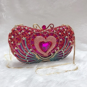 Detail of heart-shaped evening bag with pink rhinestones and colorful wing patterns
