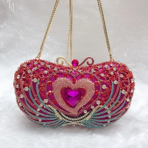Detailed macro of a heart-shaped evening clutch with multi-colored crystals and pink gemstone