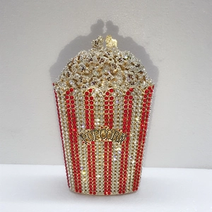 Macro shot of popcorn-shaped clutch bag with red and white rhinestones and gold clasp