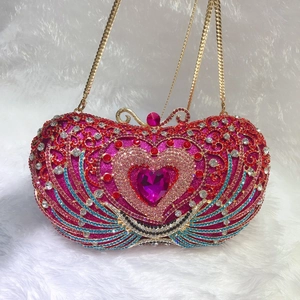 Close-up of heart-shaped evening bag with colorful crystals and golden butterfly clasp
