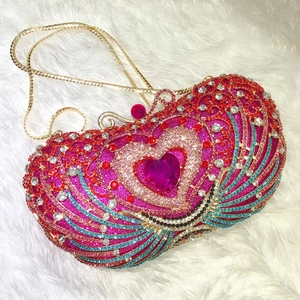 Close-up of heart-shaped pink gem and multicolored crystals on a luxury clutch bag