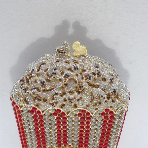 Detail of popcorn-shaped clutch bag with red and white rhinestones and heart clasp