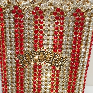 Detailed close-up of luxury popcorn bucket evening bag with red and white rhinestones