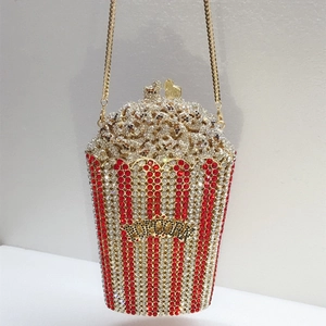 Macro view of popcorn-shaped clutch bag with red and white rhinestones and a gold chain
