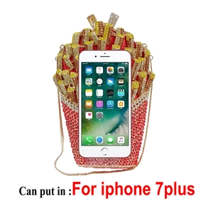 Detail of French fries shaped evening clutch with red and gold crystals next to phone