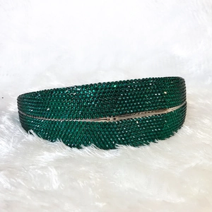 Macro view of emerald green crystal evening bag with dense rhinestone pave and metal frame