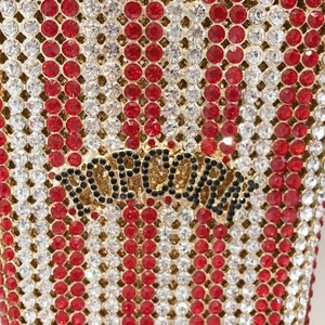 Macro detail of red and white rhinestones on popcorn clutch showing intricate hand-setting