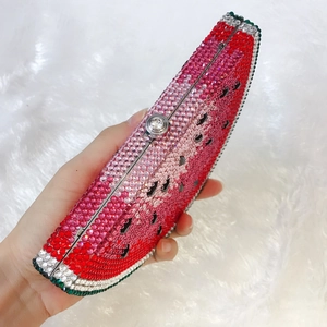Macro shot of watermelon evening bag with colorful hand-set crystals and metal clasp