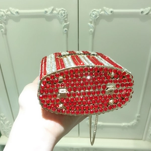 Detail of red and silver rhinestone evening clutch with gold metal frame and chain