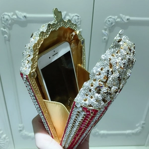 Luxurious popcorn clutch evening bag showing interior space for a smartphone
