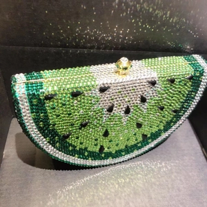Detail of watermelon-shaped crystal evening bag with green and black rhinestones