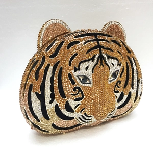 Macro detail of luxury tiger head evening clutch featuring orange and black rhinestones