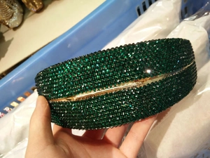 Macro shot of dark green crystal clutch with luxury metal frame and rhinestone finish