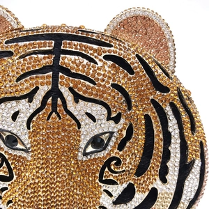 Macro view of crystal rhinestones on tiger clutch bag with detailed orange and white pattern