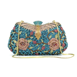 Detailed close-up of blue rhinestone evening bag featuring pink floral crystal patterns