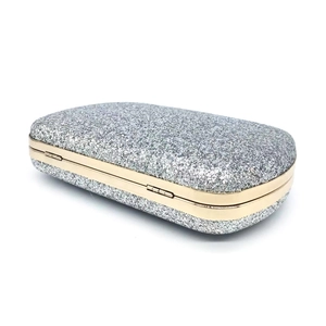 Detail of silver sequin evening clutch with gold metal frame and secure clasp closure