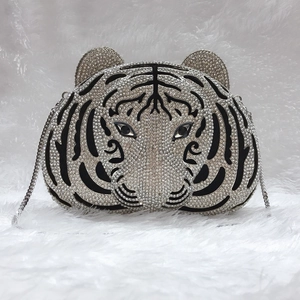 Detail of tiger shaped evening clutch featuring intricate rhinestone patterns and metal chain