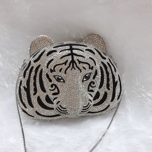 Macro shot of silver tiger head evening bag with sparkling rhinestones and metal chain