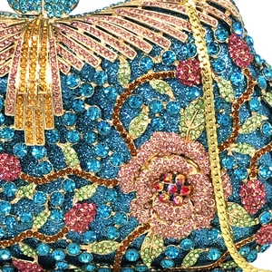 Macro shot of colorful rhinestone evening bag with floral rose patterns and gold chain