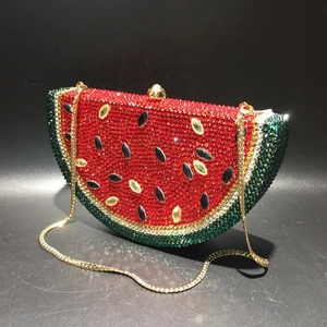 Macro detail of watermelon-shaped crystal clutch bag with hand-set sparkling rhinestones