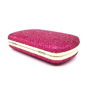 Macro view of hot pink sequin evening clutch bag with gold metal frame and hinge detail