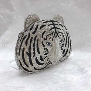 Detail of silver rhinestone tiger head evening clutch with sleek metallic chain strap