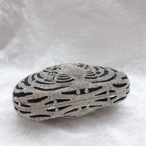 Detailed side view of luxury tiger head evening bag with silver rhinestones and crystals