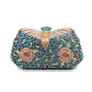 Close-up of vibrant peacock blue rhinestone clutch with pink rose floral crystal details