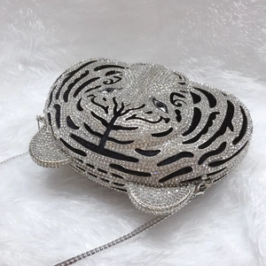 Detailed view of the tiger head evening bag featuring shimmering rhinestones and silver chain