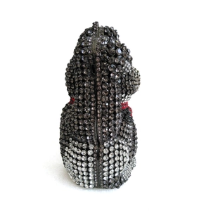 Macro shot of detailed grey and black crystal rhinestones on a dog-shaped evening clutch bag