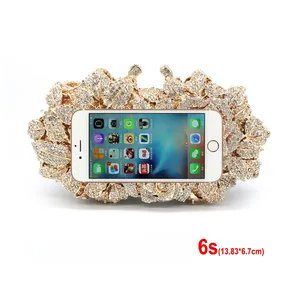 Detail view of hollow rose gold evening clutch with crystal leaf patterns and phone size scale