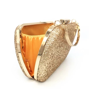 Detail showing the golden sequin evening clutch bag with yellow satin lining and metal clasp