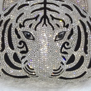 Detailed close-up of a luxury crystal-encrusted tiger head evening clutch bag