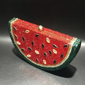 Macro shot of watermelon shaped evening clutch with red and green crystals and gold clasp