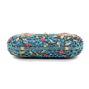 Detailed view of colorful floral rhinestone pattern on blue luxury evening clutch bag