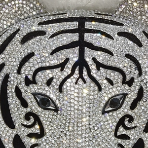 Macro shot of tiger head evening bag featuring silver rhinestones and black gem eyes