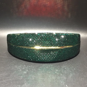 Detailed view of handmade green crystal evening clutch with gold metal frame