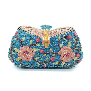 Macro view of luxury evening clutch featuring sapphire blue rhinestones and pink floral pattern