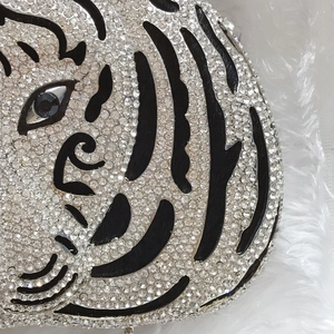 Detailed close-up of tiger head evening bag with inlaid rhinestones and black tiger stripes