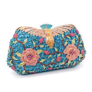 Close-up of luxury rhinestones floral pattern and golden fan clasp on navy evening bag