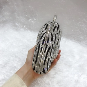 Macro shot of silver crystal evening clutch with hollow streamline pattern and hand grip