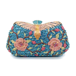 Detail of floral rhinestone clutch with blue and pink crystals and golden fan clasp