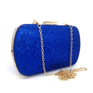 Detail of royal blue sequined clutch with elegant gold metal frame and chain strap