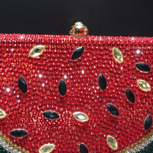 Macro shot of hand-set red and green rhinestones on a watermelon-shaped evening clutch
