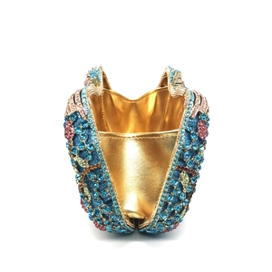 Detailed interior of luxury rhinestone clutch bag featuring gold lining and crystal exterior