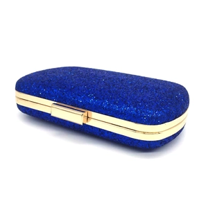 Macro view of navy blue sequin evening clutch with golden metallic frame and glitter