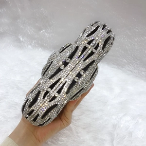 Macro view of silver hollow evening clutch bag featuring intricate crystal rhinestones